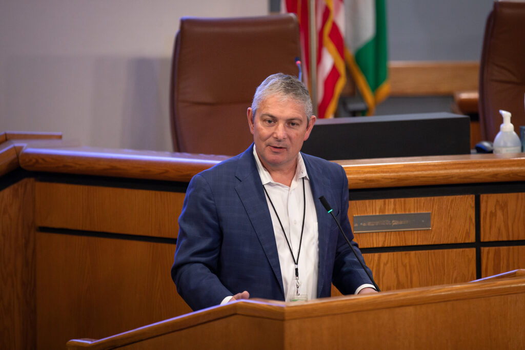 Close up of the
County Manager speaking at the podium.